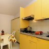 Cucina con mobili gialli e tavolo fiorito.