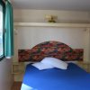 Letto blu con finestra e tende verdi a sinistra.