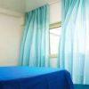 Camera con letto blu e tende azzurre.