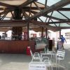 Chiosco all'aperto con tetto in legno, tavoli e sedie di metallo.
