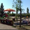 Parco giochi con biciclette e ombrelloni.
