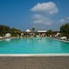 Piscina all'aperto con lettini e cielo azzurro.