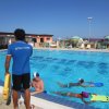 Istruttore di nuoto con bambini in piscina.