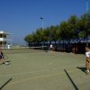 Due persone giocano a tennis su un campo all'aperto.