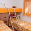Cameretta con letti a castello arancioni e peluche.