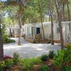 Bungalows tra gli alberi, con vialetti e giardino curato.