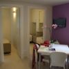 Interno di una stanza con tavolo, sedie e parete viola.