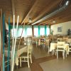 Sala da pranzo con tavoli apparecchiati e soffitto in legno.