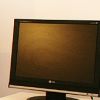 Uno schermo di computer LG spento, appoggiato su una scrivania bianca.