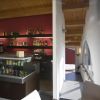 Interno di un bar con scaffali di bottiglie, frigorifero di bevande e arredi moderni.
