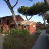 Edifici rossi immersi tra alberi alti, con vialetti pavimentati.
