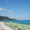Spiaggia con ombrelloni gialli e verdi.