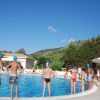 Persone in costume e cuffie blu accanto alla piscina.