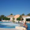 Piscina esterna con persone e ombrellone arancione.