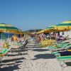 Ombrelloni e lettini su una spiaggia affollata.