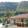 Edificio con tetto rosso e colline verdi sullo sfondo.