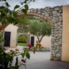 Arco di pietra con piante e albero al centro.