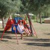 Bambini giocano sull'altalena in un giardino.