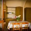 Tavolo apparecchiato con fiori, cucina sullo sfondo.