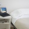 Laptop su tavolino accanto a letto.