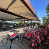 Terrazza esterna con sedie e fiori rosa.