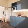 Cucina moderna con mobili blu e microonde.