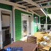 Terrazza in legno con lettini e tavolo da pranzo.