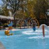 Bambini giocano in una piscina con giochi d'acqua colorati.