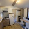 Cucina moderna con frigo, tavolo e divano.
