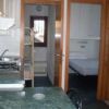 Cucina con piano di lavoro verde, vista su camera da letto.