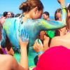 Ragazza dipinta di blu al sole su una spiaggia.