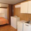Un monolocale con cucina moderna, letto matrimoniale e pavimento in legno.