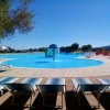 Piscina con fontana e lettini intorno.