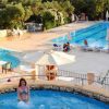 Piscina grande con sdraio e una piscina più piccola con persona.