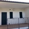 Veranda con porta e finestre verdi.