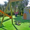 Giardino giochi con altalene e scivolo.