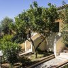 Due scale esterne che conducono a una casa, circondate da alberi verdi.