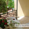 Terrazza con tavolo apparecchiato, sedie bianche, e piante verdi.