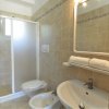 Bagno con doccia, lavabo, bidet e WC. Asciugamani su mensola, specchio illuminato.