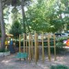 Area giochi con scivolo, panchina e struttura da arrampicata.