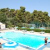 Piscina all'aperto con ombrelloni blu a strisce.