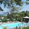 Piscina all'aperto con ombrelloni e vista sul mare.