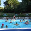 Persone in piscina fanno ginnastica acquatica.
