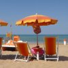 Ombrelloni e sedie a sdraio arancioni sulla spiaggia.