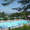 Piscina all'aperto con ombrelloni blu, vista sul mare.