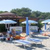 Spiaggia con ombrelloni blu e lettini.