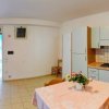 Cucina luminosa con tavolo apparecchiato e vasi di fiori, armadi azzurri e fornelli.