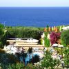 Vista su mare, piscina e vegetazione variopinta.