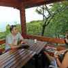 Due persone sedute su una terrazza di legno con vista mare.