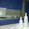 Cucina moderna con mobili blu e decorazioni bianche.